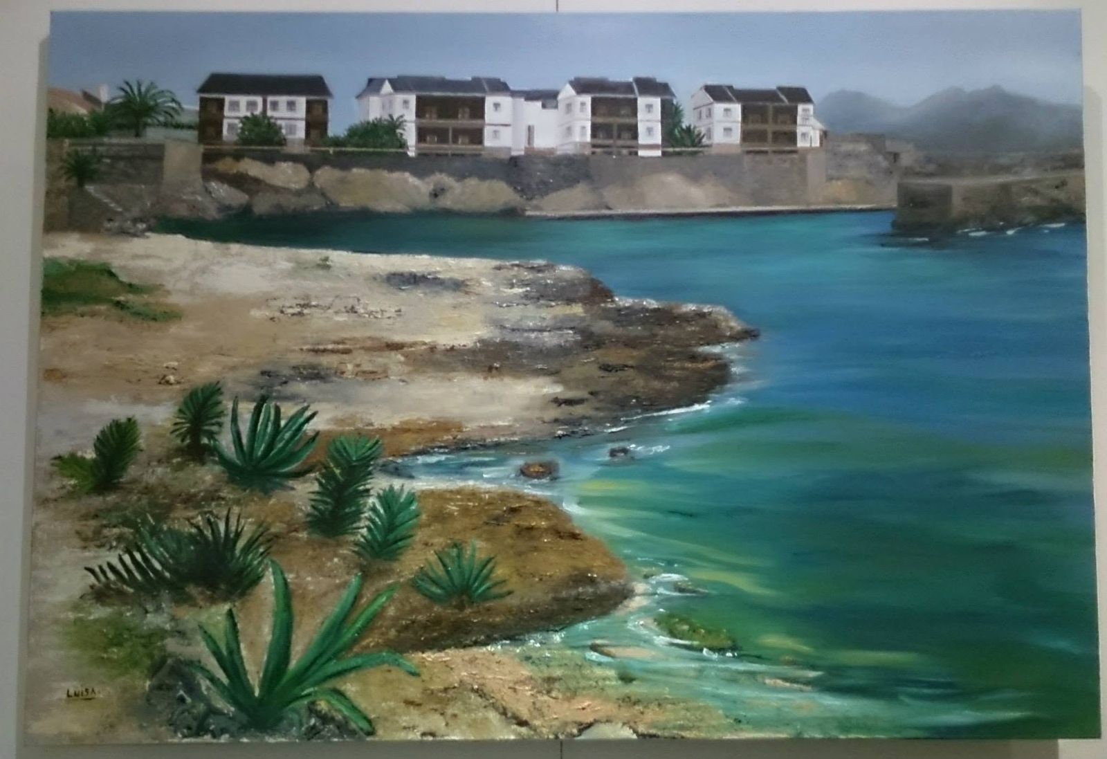 Paisaje de costa mediterránea con chumberas y casas blancas