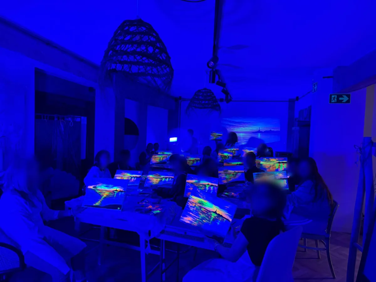 Grupo pintando con colores fluorescentes bajo luz ultravioleta